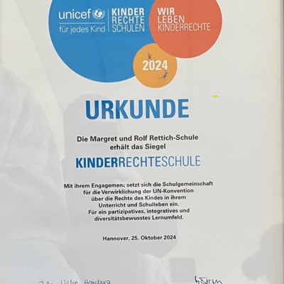 Wei&szlig;e Urkunde mit farbigen Kreisen.